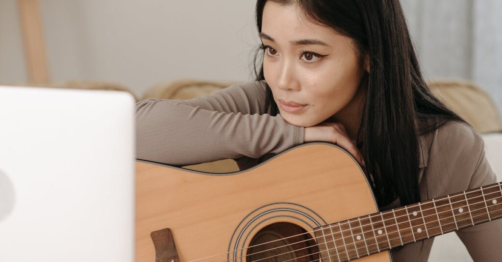 A young woman engages in an online guitar lesson, sitting comfortably at home.