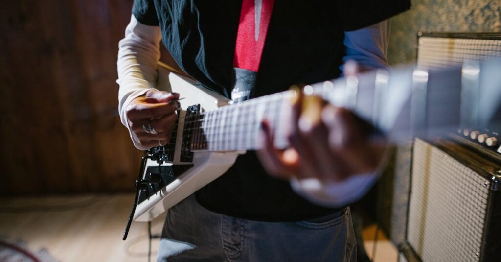 Close-up of a musician playing an electric guitar indoors, focus on hands and instrument.