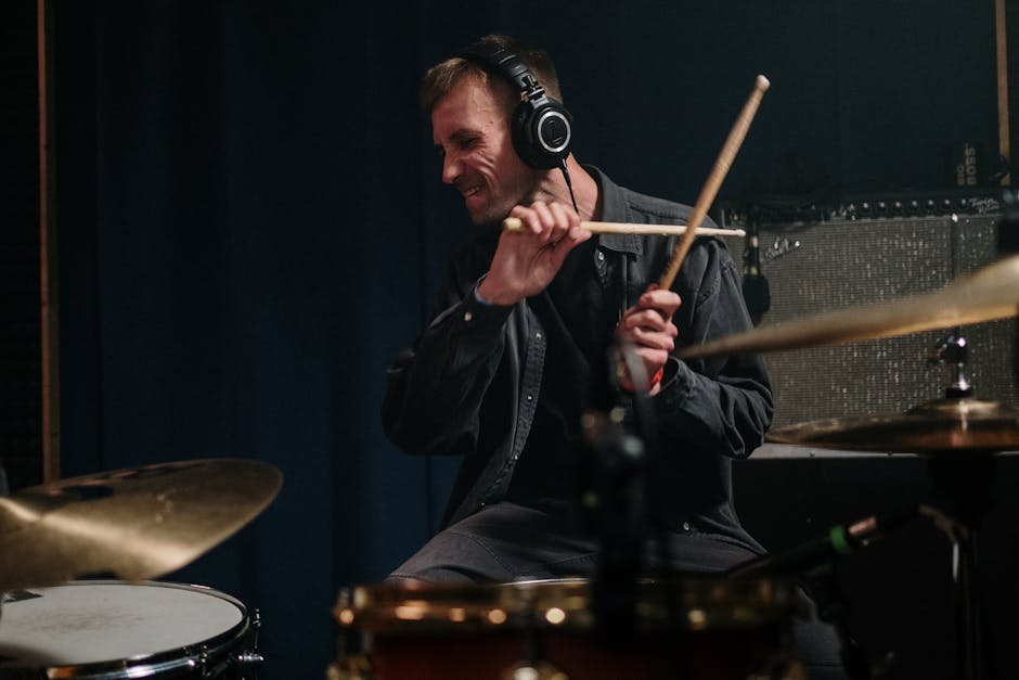 A passionate drummer energetically playing drums in a music studio.